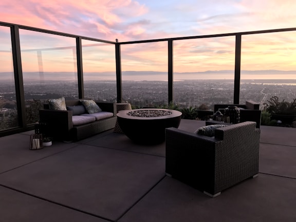 Evening view of a cozy outdoor seating area enclosed by glass walls