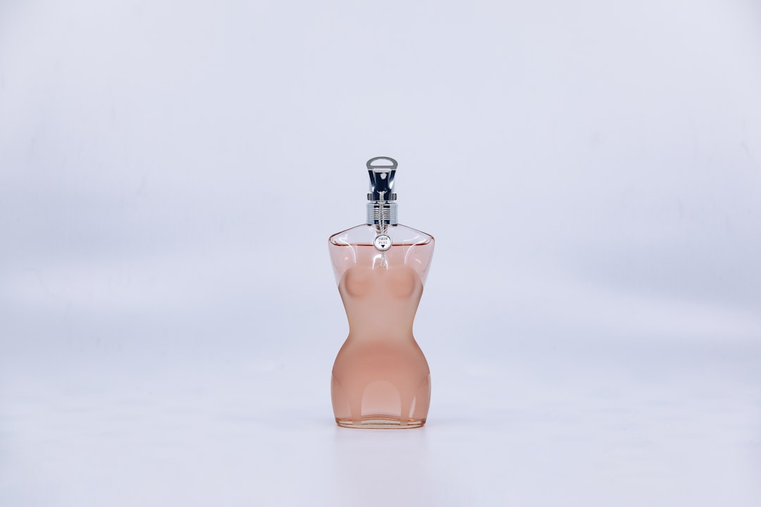 orange glass perfume bottle on white surface