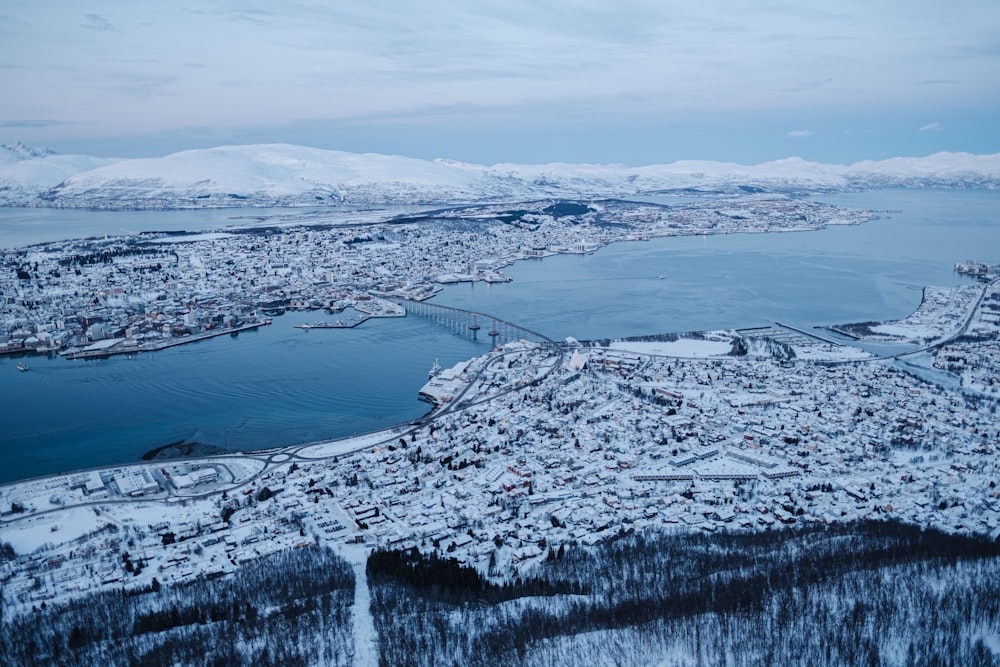 snow covered mountain near body of water during daytime