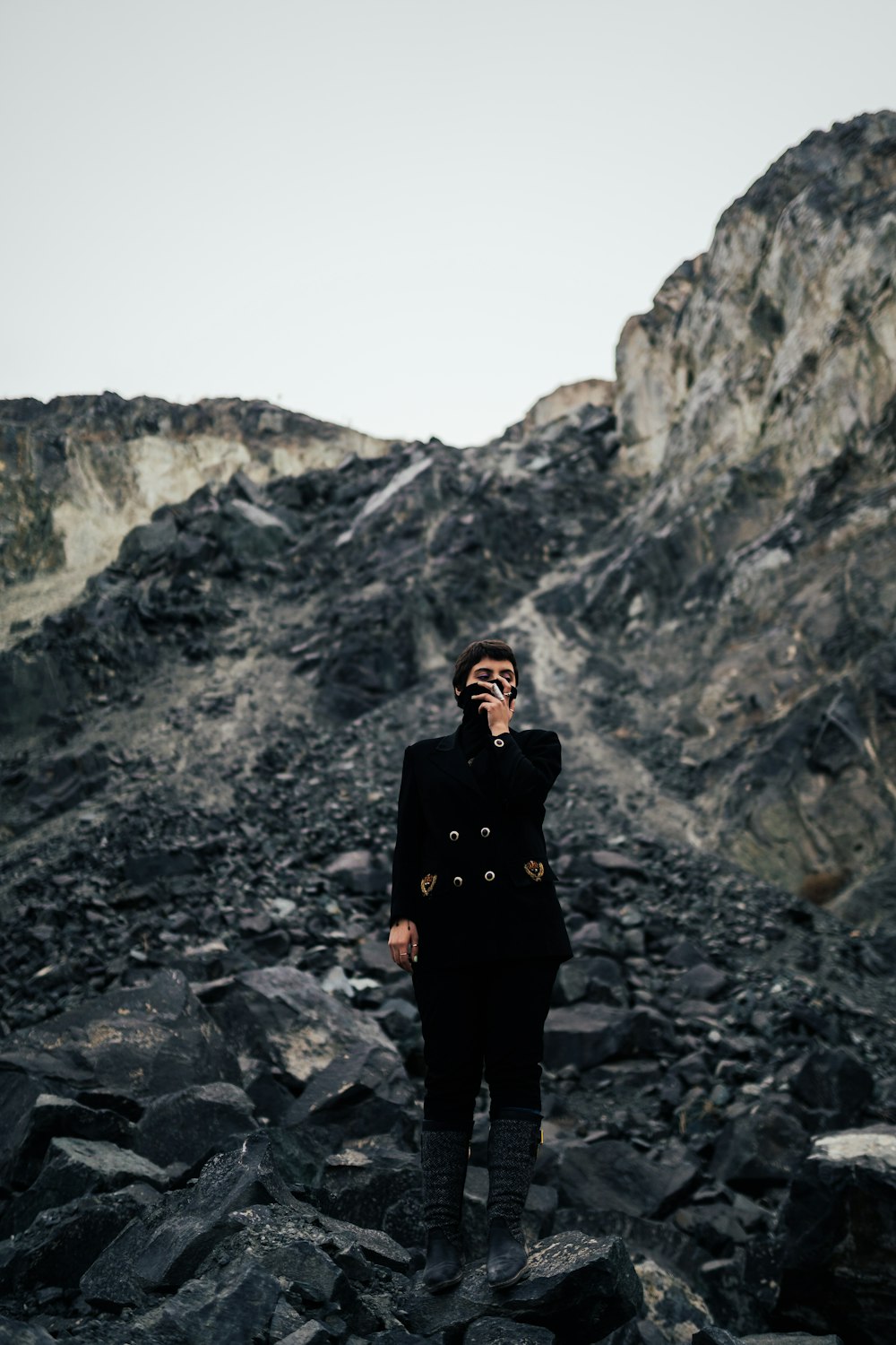 woman in black jacket standing on rocky mountain during daytime