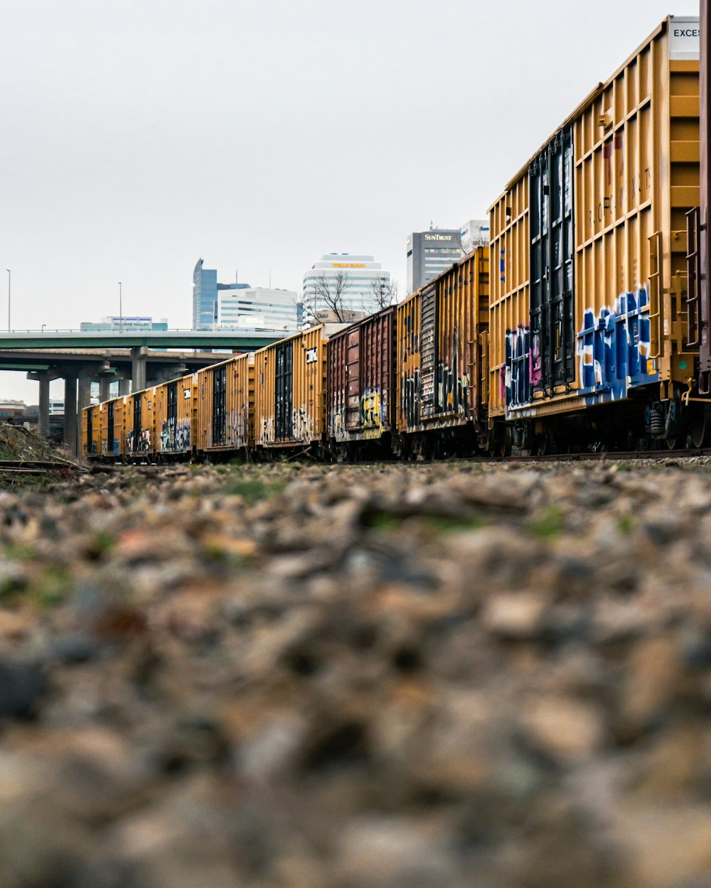 Brauner und grüner Zug tagsüber auf Bahngleisen