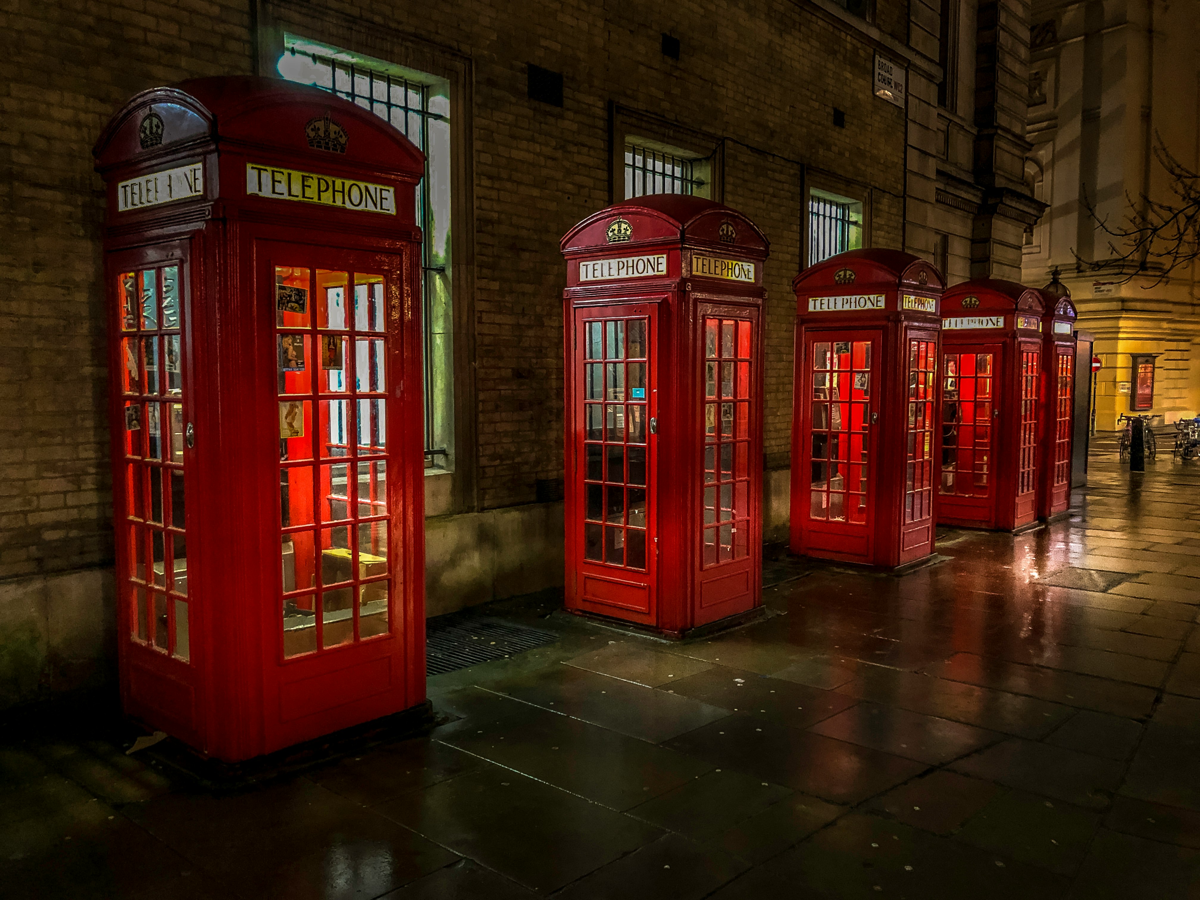 red telephone booth on brown brick floor