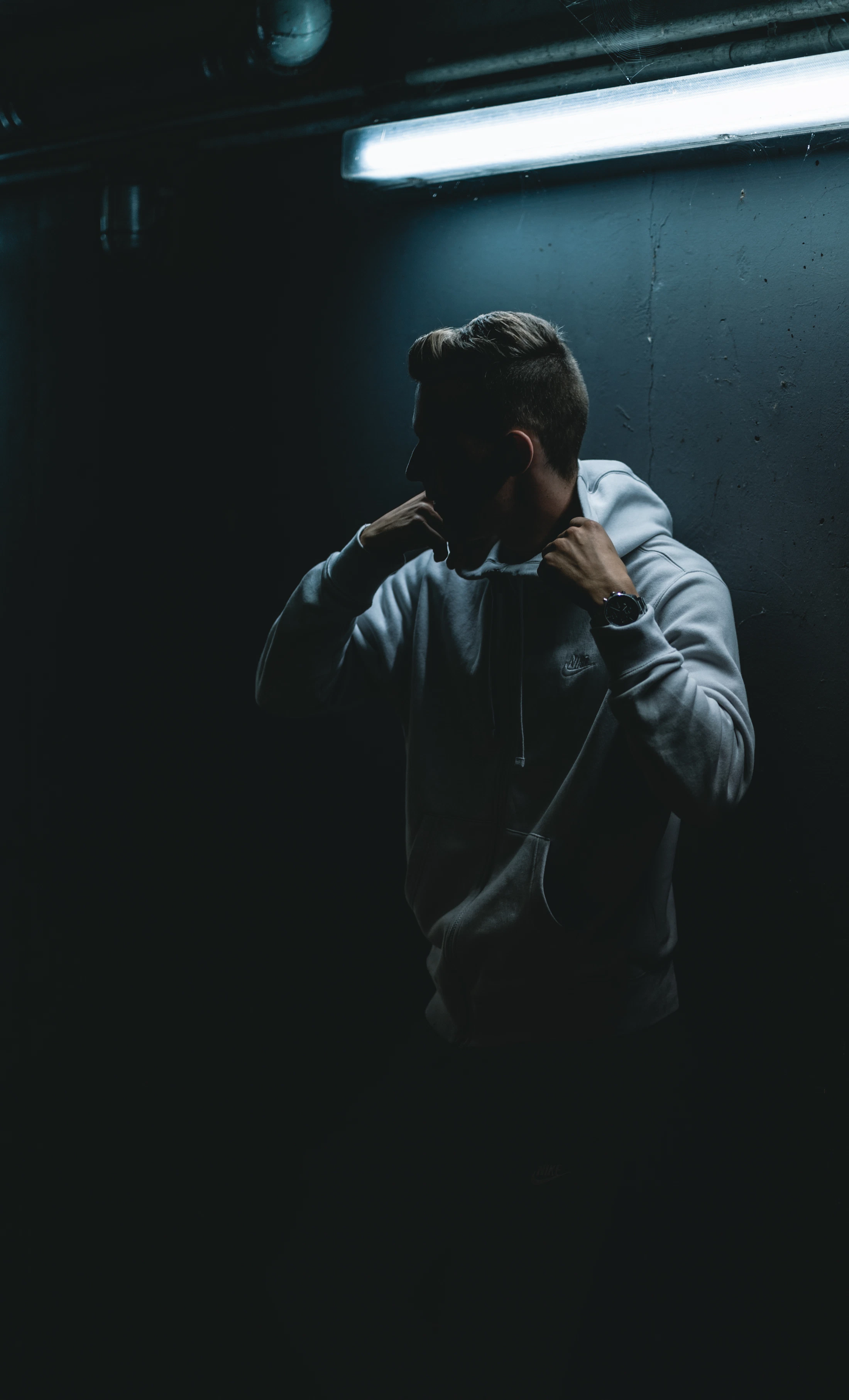 Model wearing dark outerwear in an underground city space