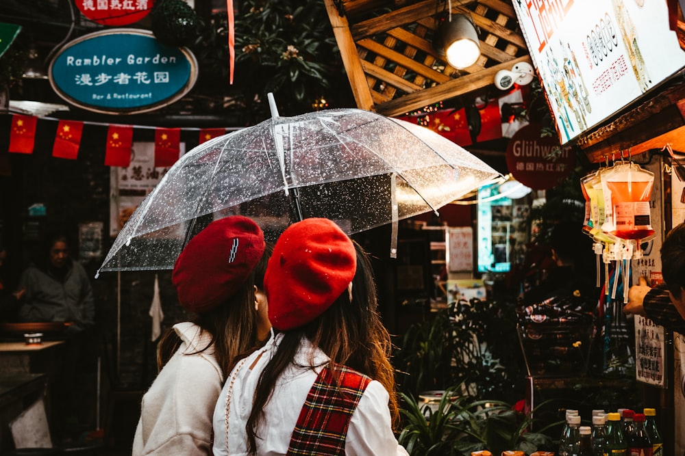 woman in red knit cap and white jacket holding umbrella