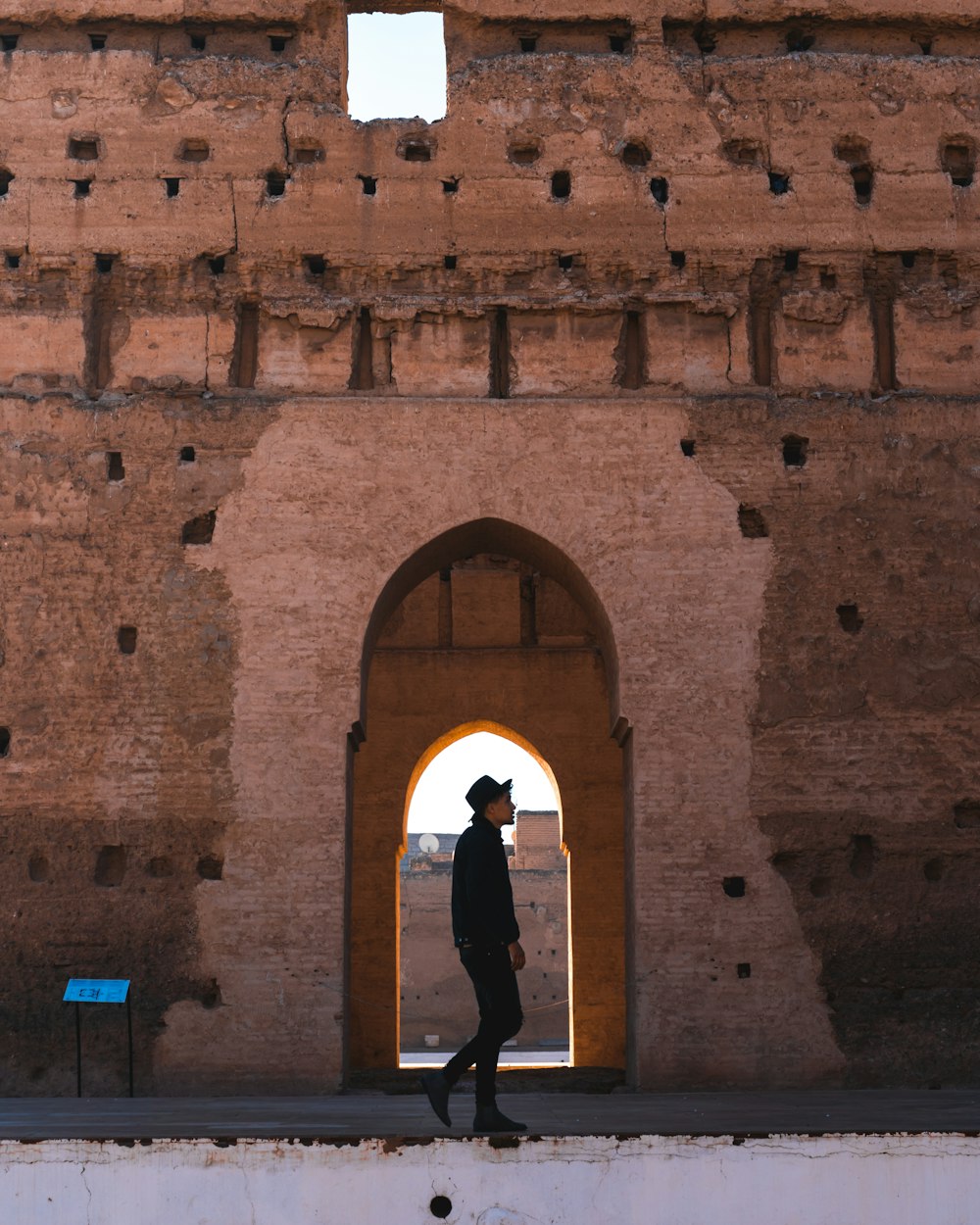 woman in black long sleeve shirt standing in front of brown brick wall