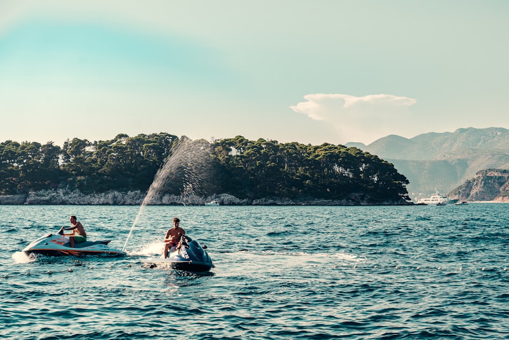 man in red shirt riding on white and blue kayak on sea during daytime