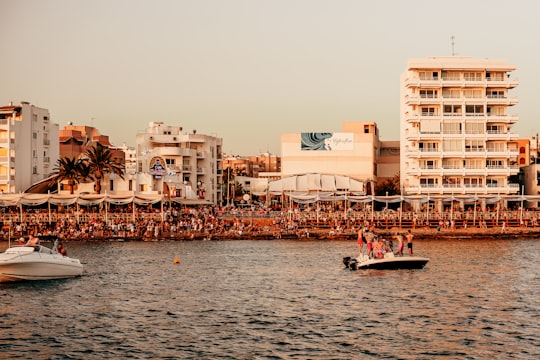 people riding on boat on sea near buildings during daytime in Ibiza Spain