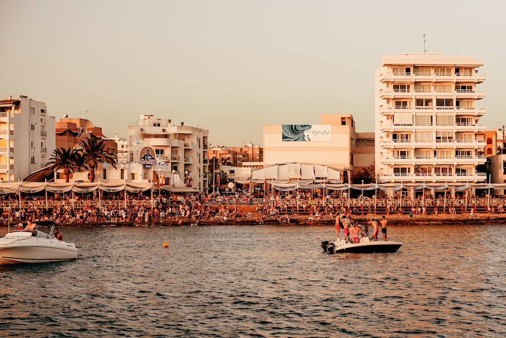 people riding on boat on sea near buildings during daytime