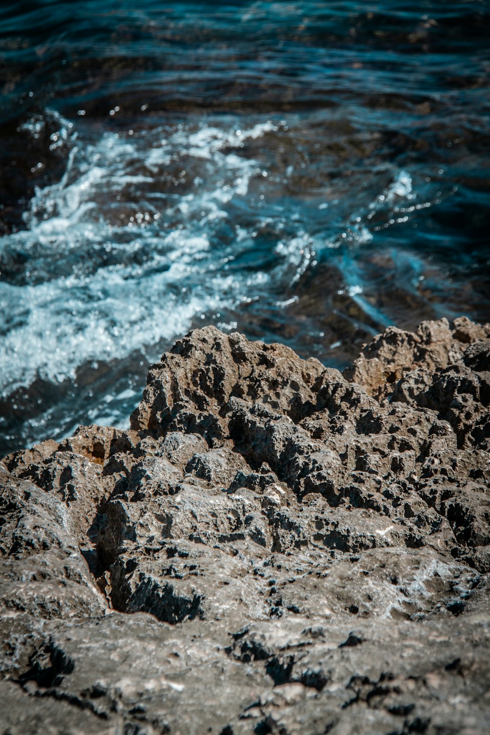 brown rocky shore with water waves during daytime