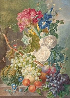 A still life painting featuring an abundant arrangement of vibrant fruits and flowers. Glistening green and purple grapes cascade over the edge, while plump oranges and a watermelon sit nearby. Luxurious blooms in shades of red, blue, and white add dramatic flair, and a backdrop of lush greenery enhances the richness of the composition.