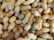 A large pile of unshelled peanuts with textured, tan-colored shells piled closely together, creating a natural and rustic appearance.