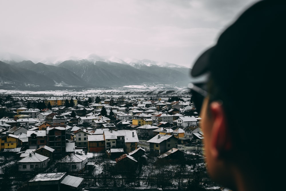 personne en veste noire regardant la ville pendant la journée