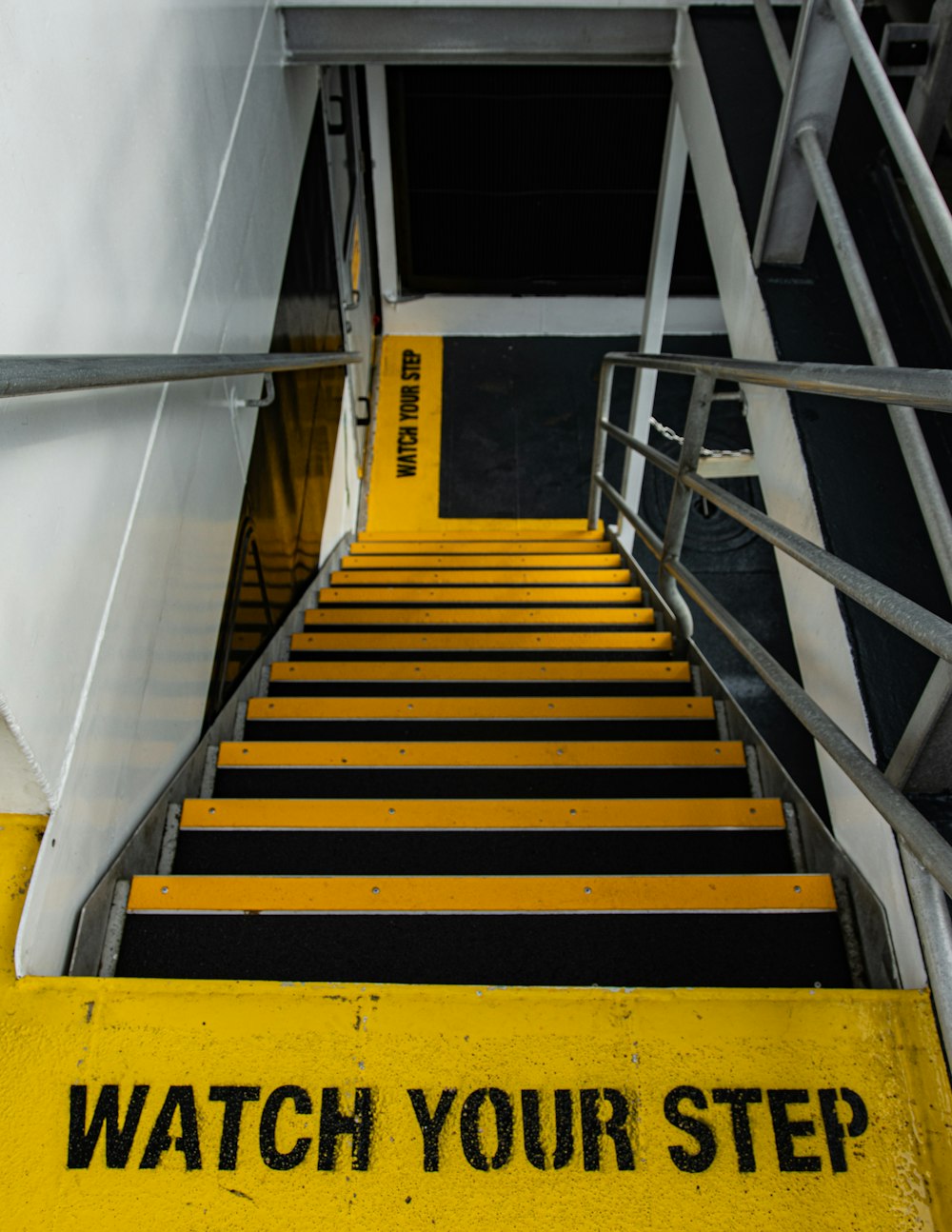 yellow and black staircase near white wall