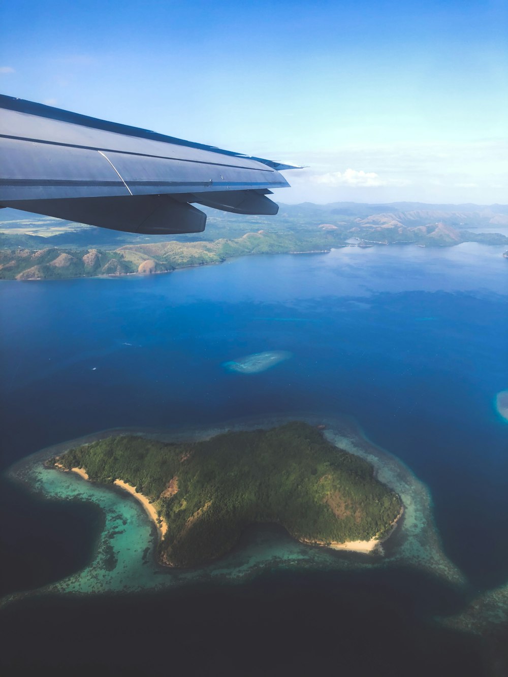 aerial view of green and brown land and blue sea during daytime