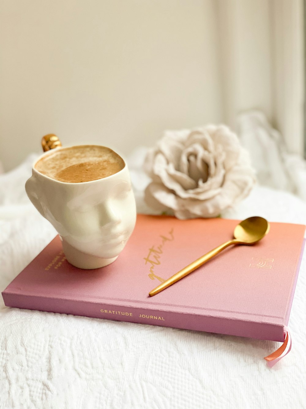 white ceramic cup on red book