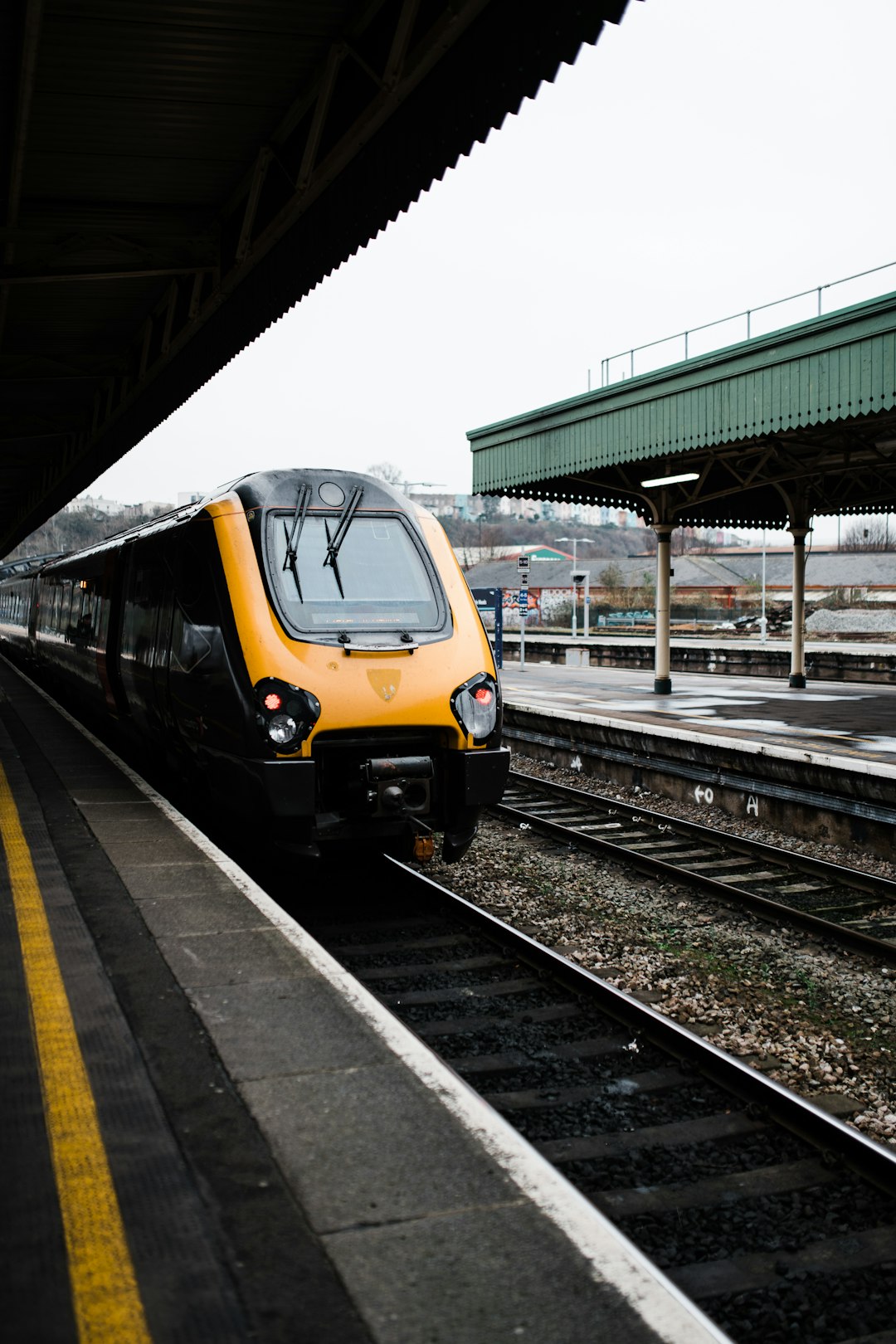 yellow and black train on rail tracks during daytime