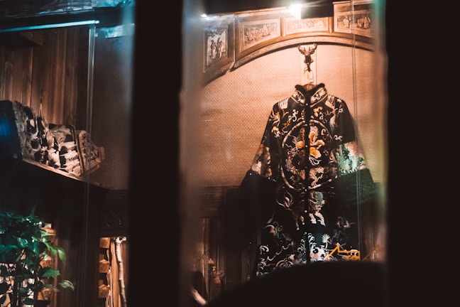 A beautifully embroidered Moroccan caftan displayed on a mannequin with soft lighting highlighting the intricate details.