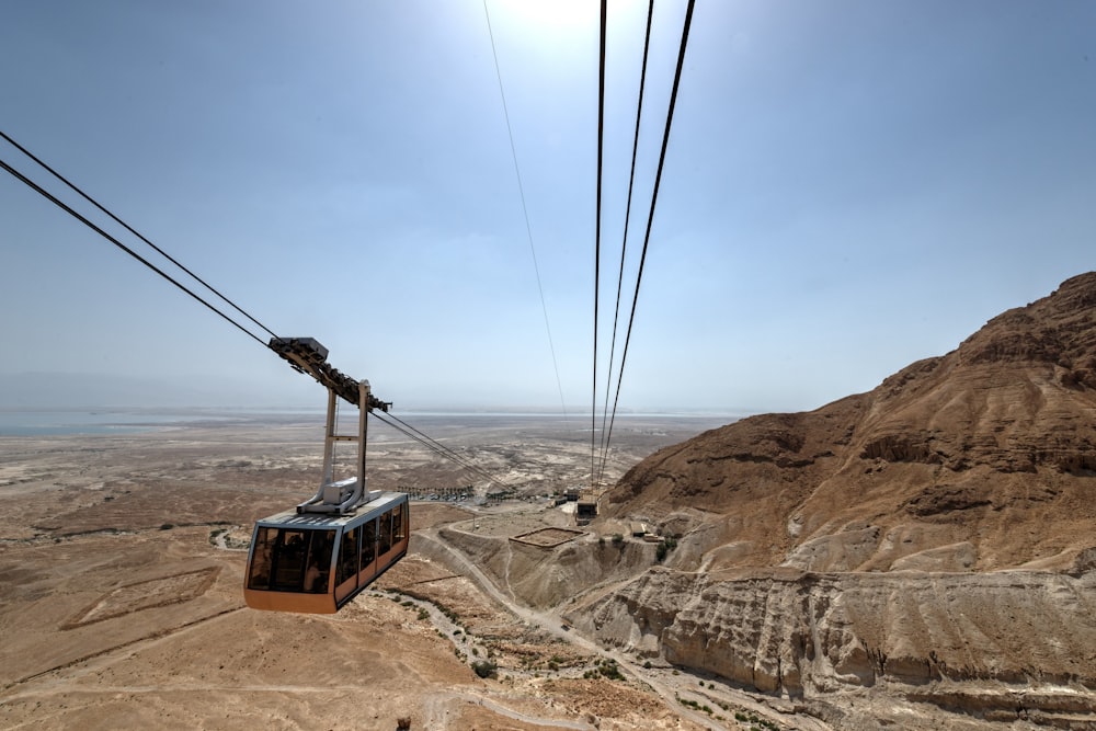 black and brown cable car on brown rock formation during daytime