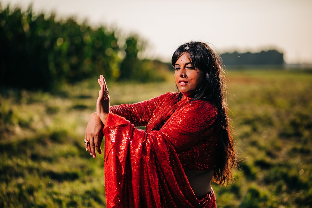 woman in red long sleeve dress standing on green grass field during daytime