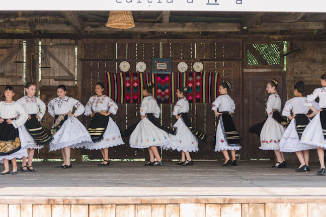 A group of dancers from Ansambl Vila performing a traditional folk dance on stage.
