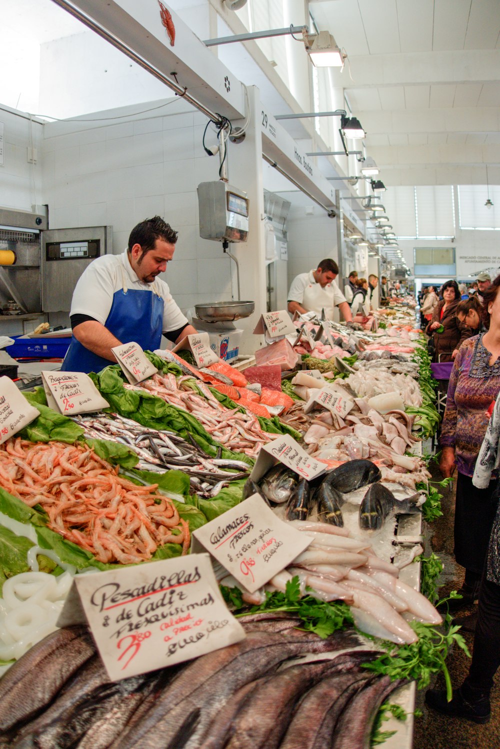 people in white shirt standing in front of raw meat