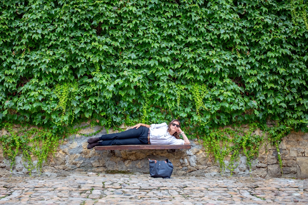 woman lying on brown wooden bench