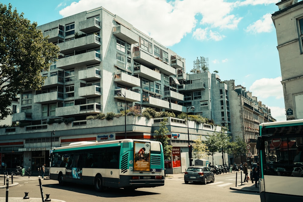 white and red bus on road near white concrete building during daytime