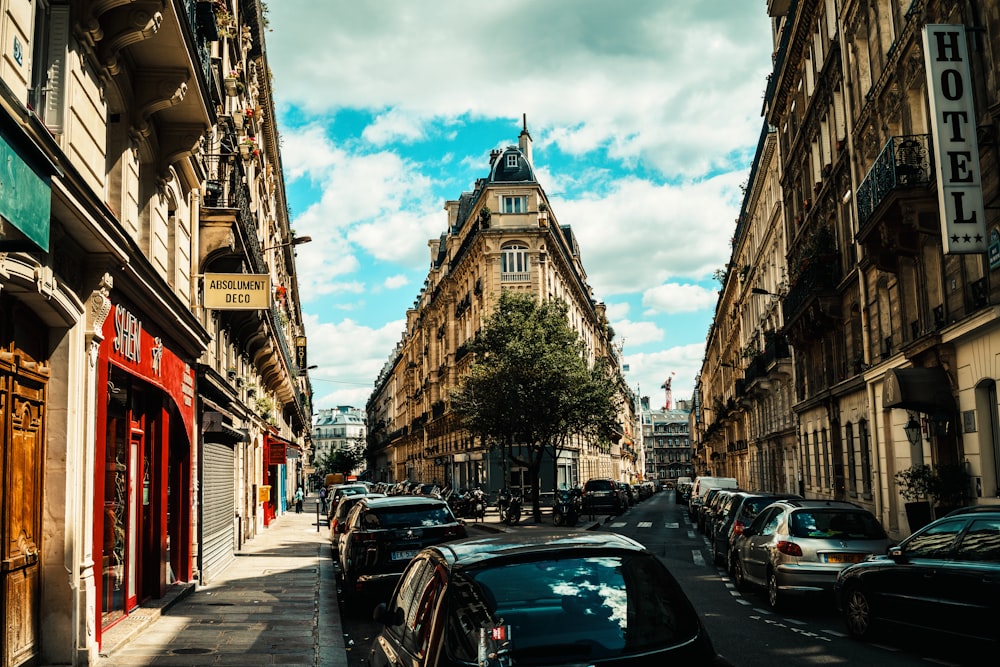 cars parked on side of road near high rise buildings during daytime