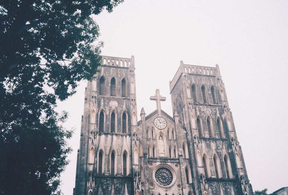 gray concrete church near green trees during daytime