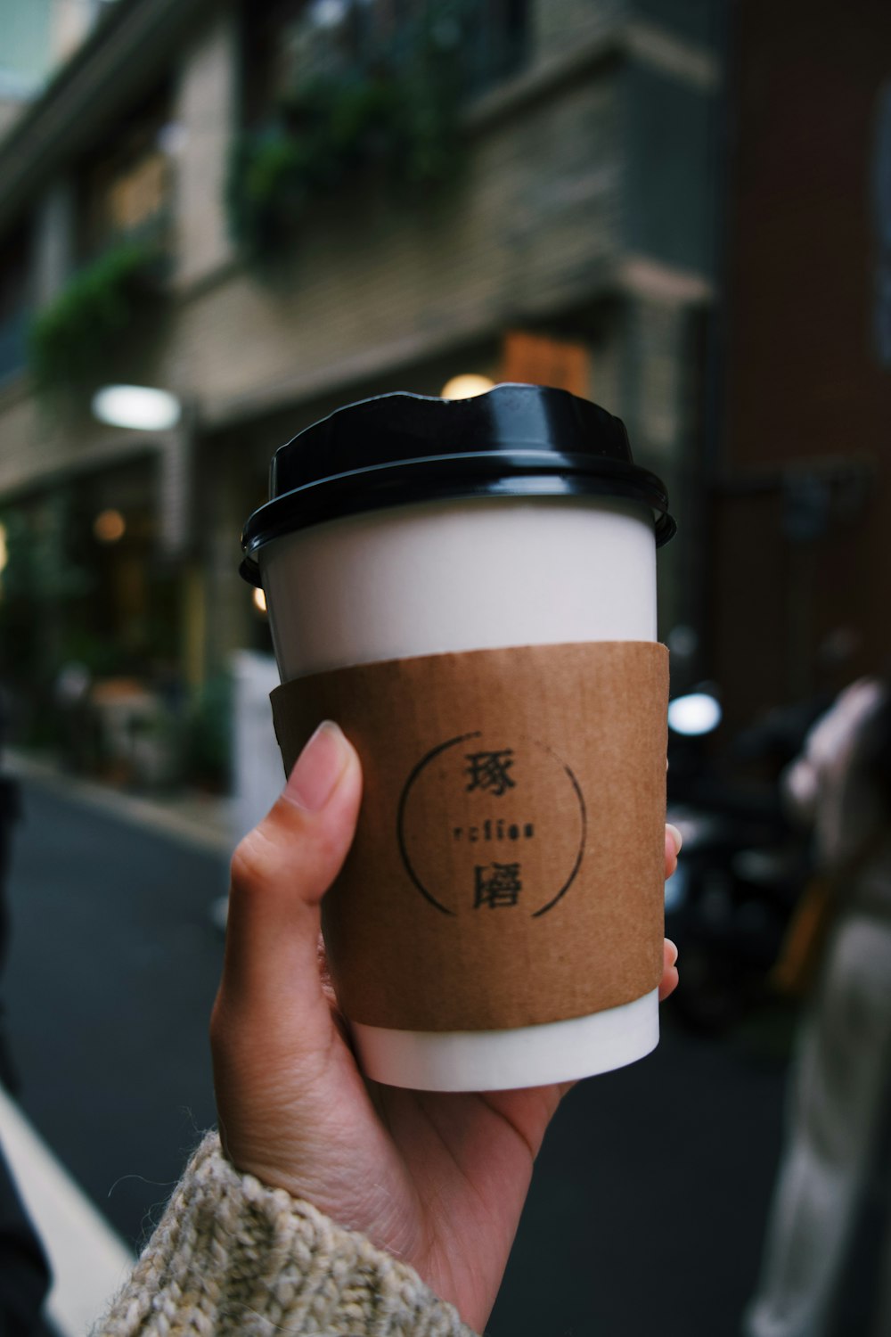 person holding white and brown paper cup