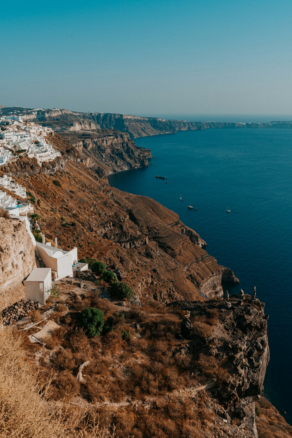 white concrete building on cliff near body of water during daytime