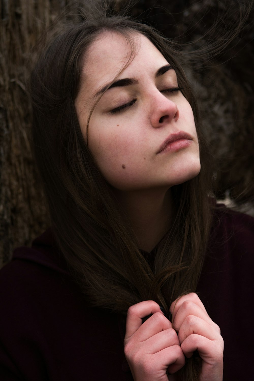 woman in red hoodie near brown tree