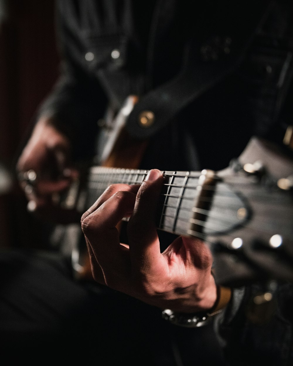 man playing guitar in close up photography