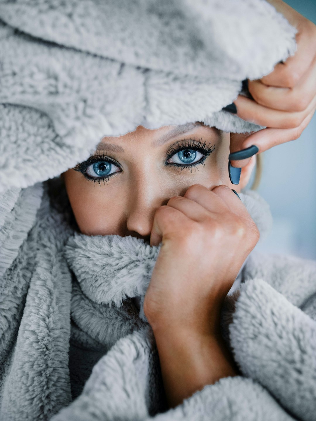 woman in white bath robe holding blue ceramic mug