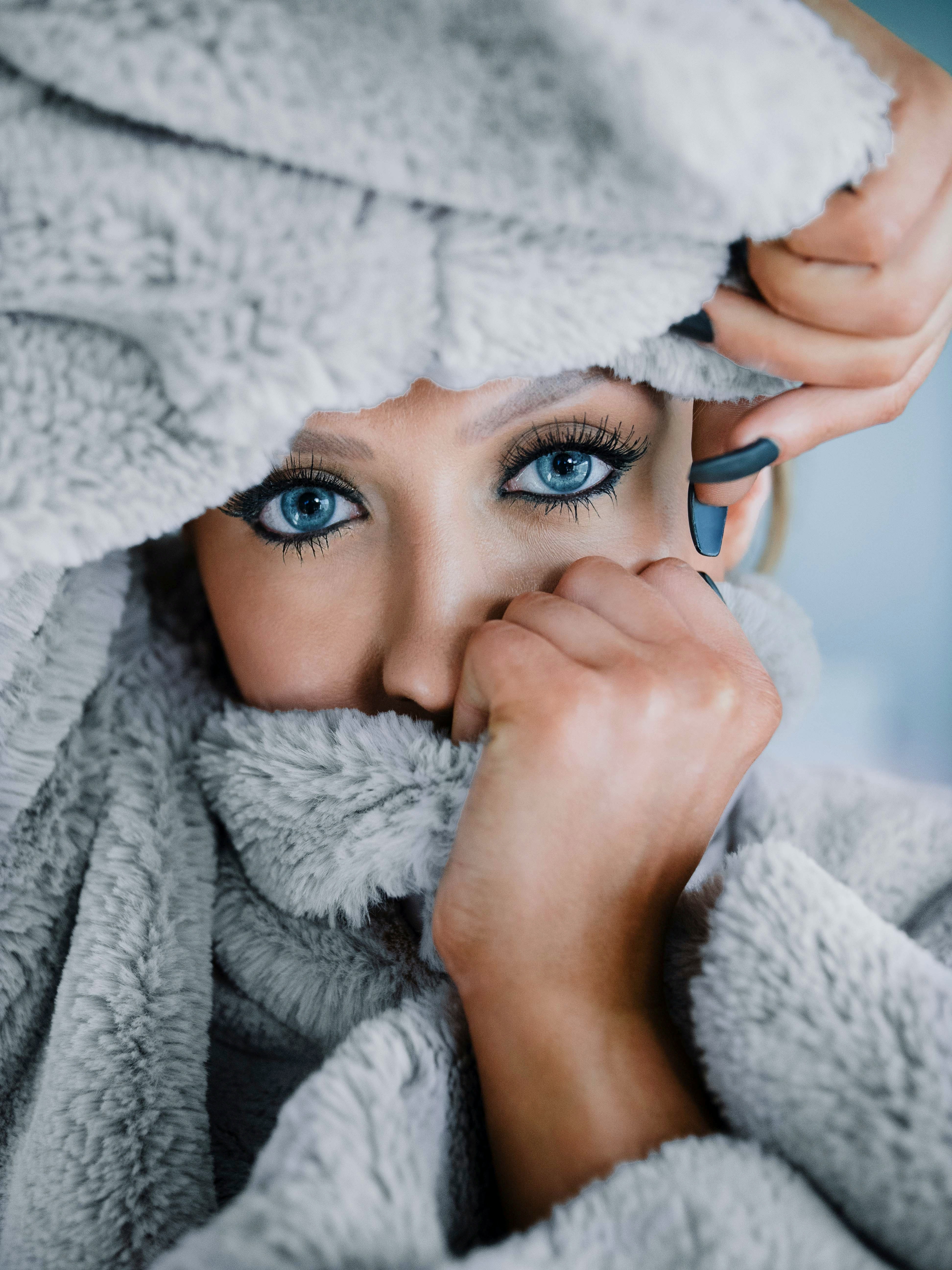 woman in white bath robe holding blue ceramic mug