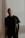 man in black crew neck t-shirt standing near brown curtain