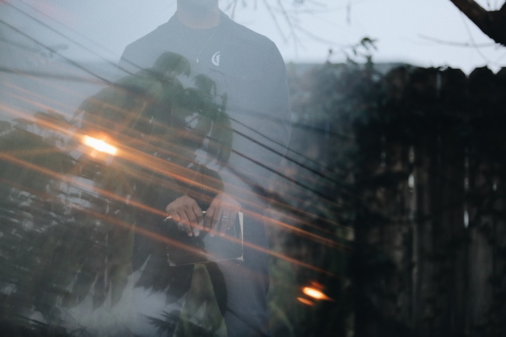 man in black jacket standing on road during daytime