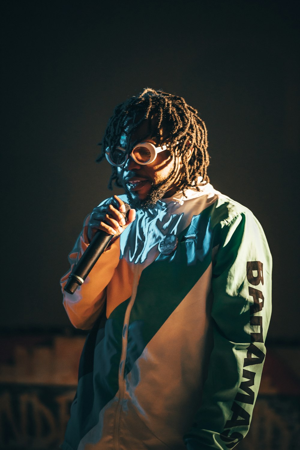 man in white and blue long sleeve shirt holding microphone