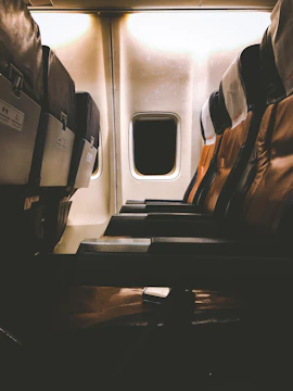 Dark, minimalist private jet interior with ambient lighting and leather seats.