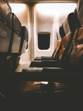 Interior view of a midsize jet cabin with plush leather seats and ambient lighting.
