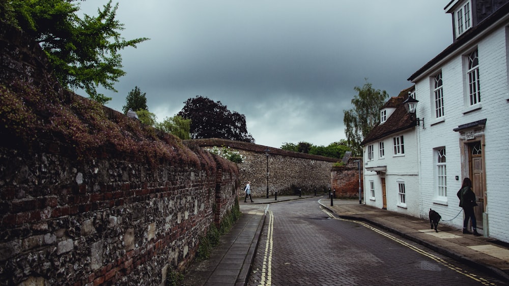 white and brown concrete house beside gray concrete road under gray sky