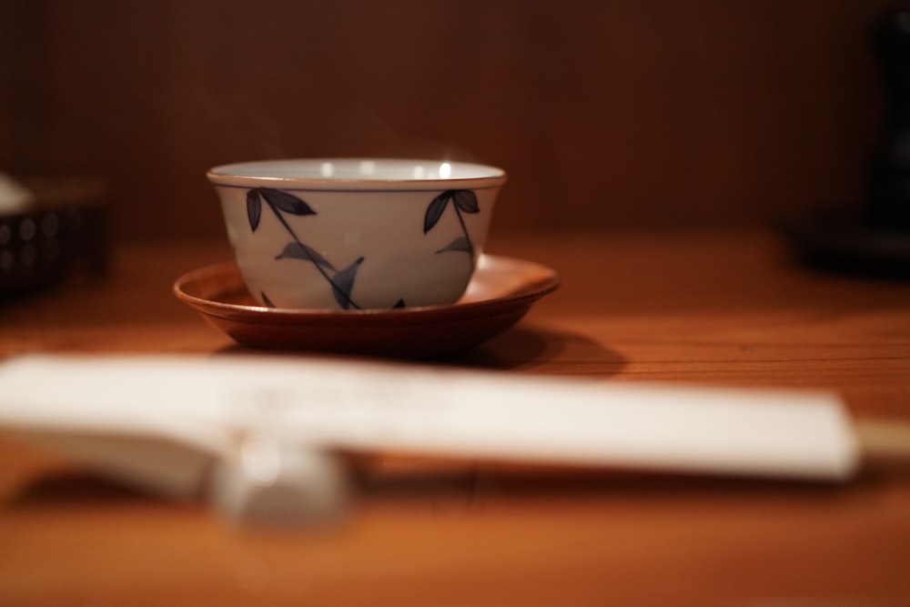 tigela de cerâmica branca e azul na mesa de madeira marrom