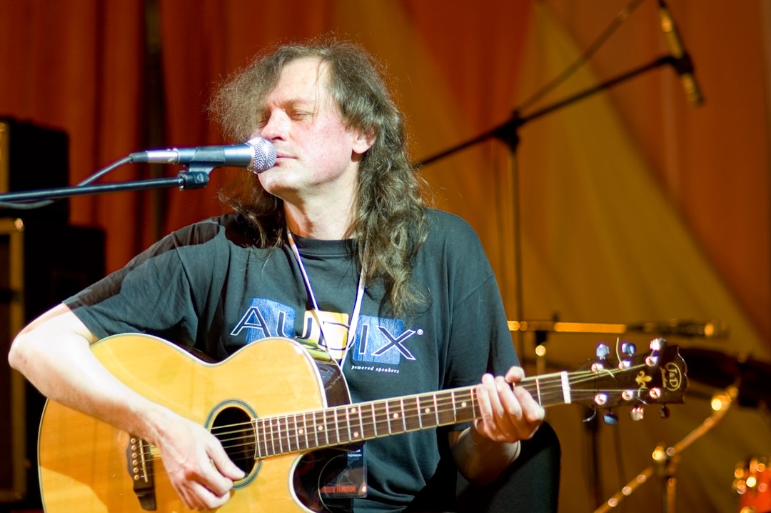 man in black long sleeve shirt playing guitar