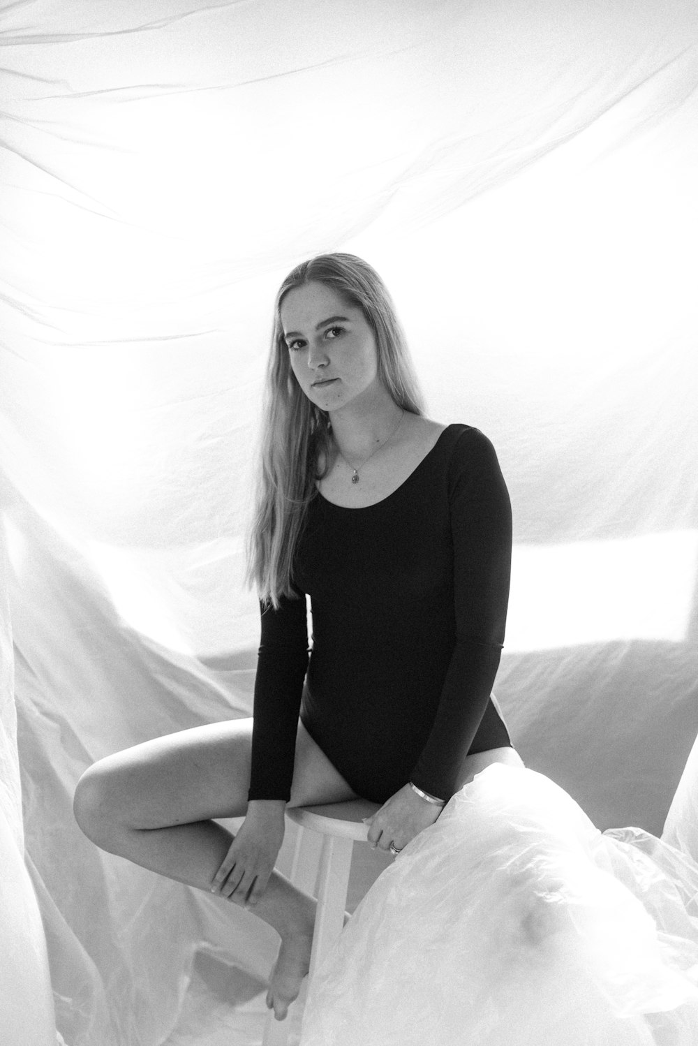 woman in black tank top sitting on white textile