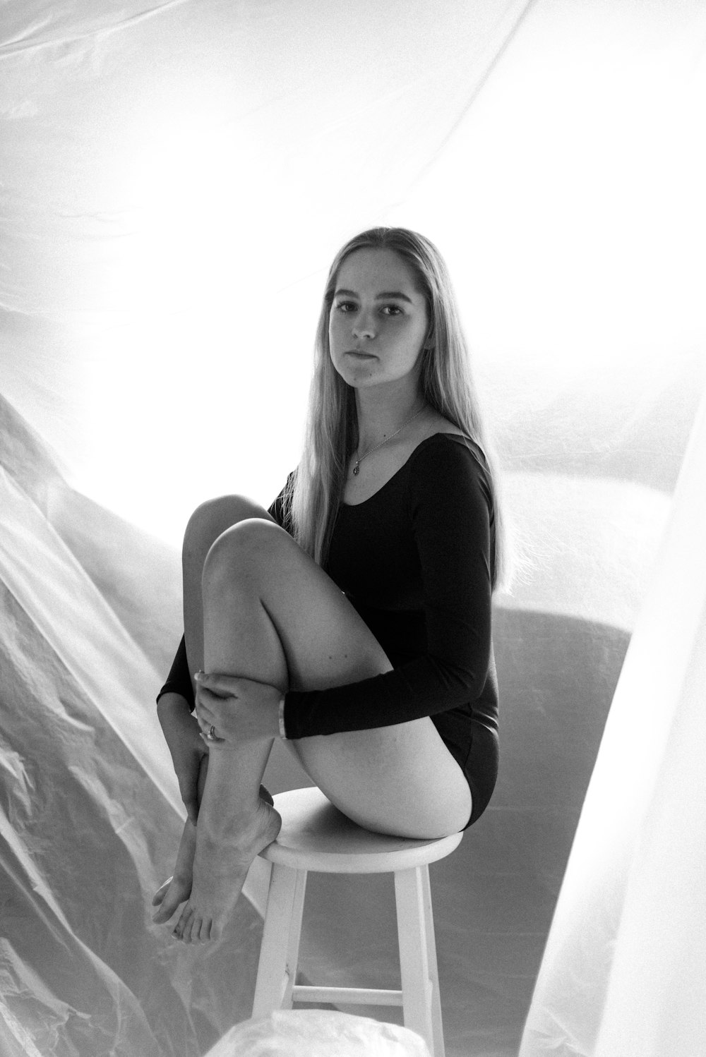 woman in black tank top sitting on white textile