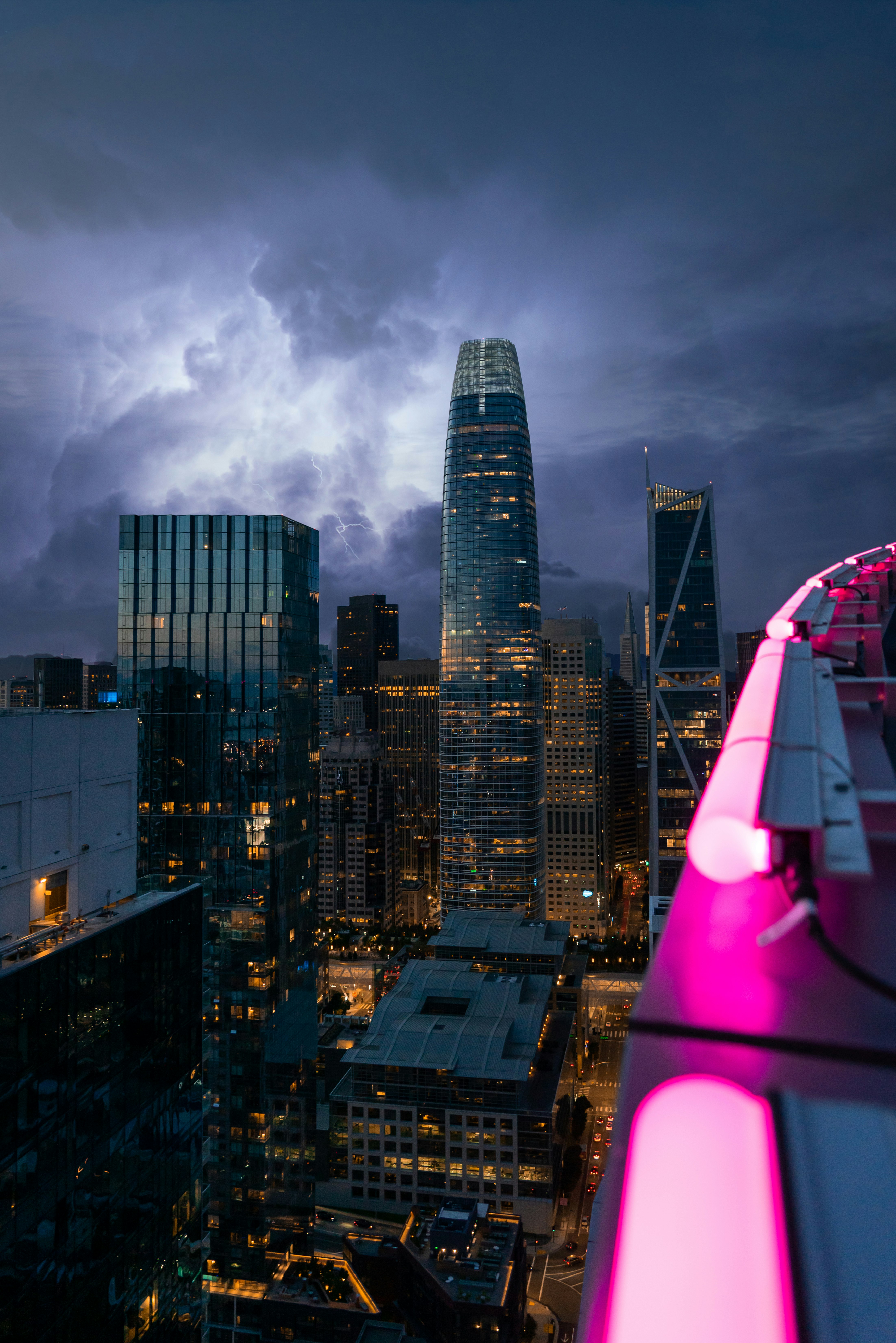 high rise buildings under gray clouds during night time