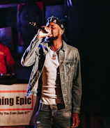 Close-up of Jottade holding a microphone during a live rap show.