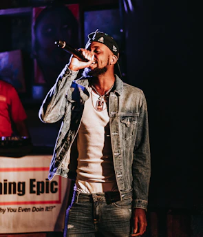 Close-up of Jottade holding a microphone during a live rap show.