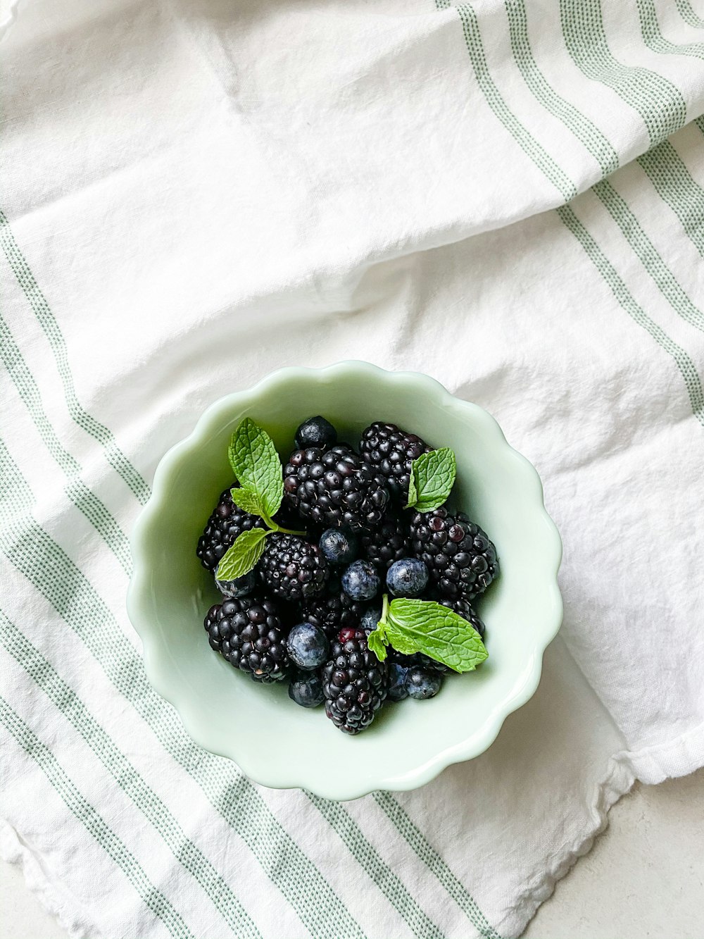 blue berries on green ceramic bowl