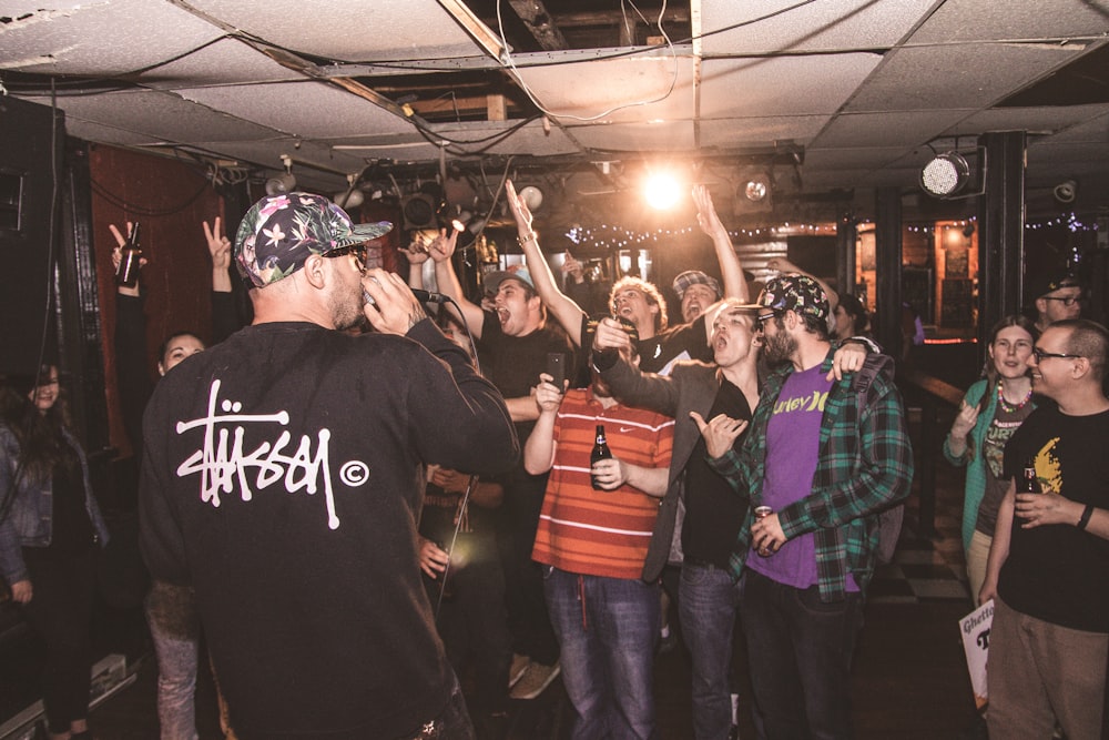 group of people standing and raising hands